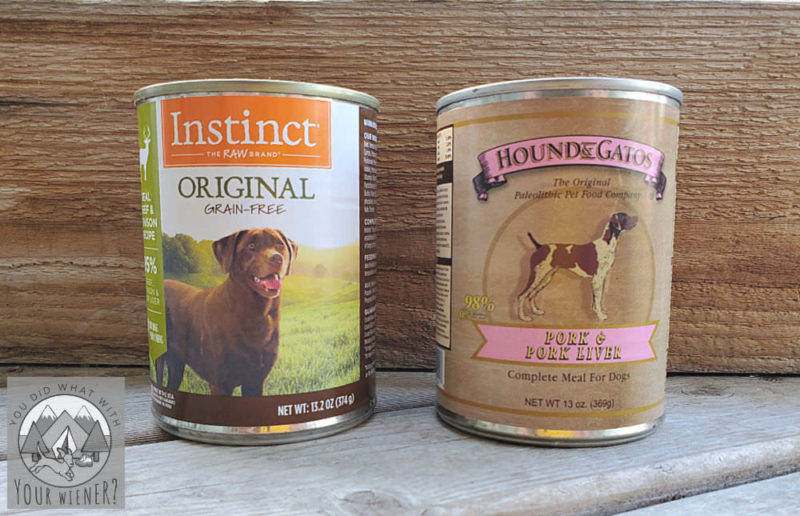 Two cans of Instinct and Hound & Gatos wet dog food